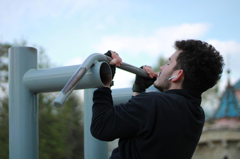 Muscular man demonstrating impressive strength with a flawless pull-up, showcasing effective upper body workout and fitness achievement.