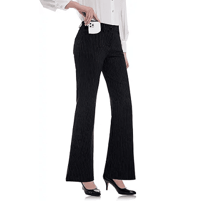 woman wears bootcut trousers with heels; she is demonstrating that the pockets are big enough to fit your phone