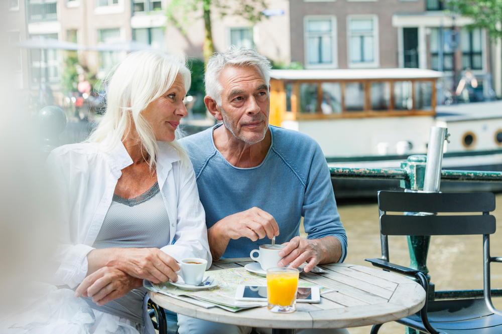 An older couple enjoying a glass of freshly squeezed orange juice, emphasizing the importance of mindful carbohydrate intake and portion control in managing diabetes and blood sugar levels