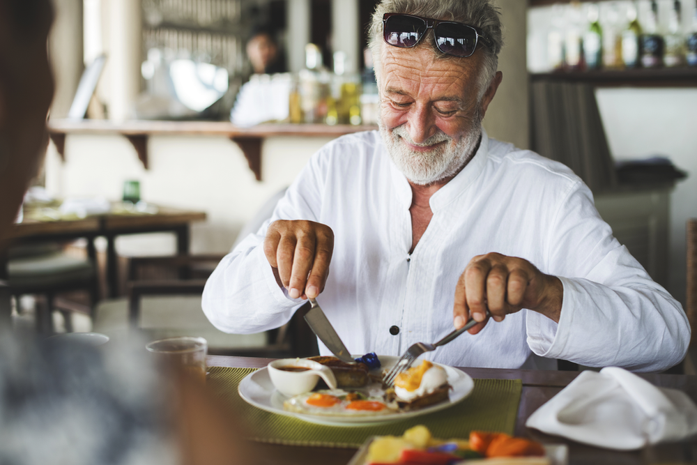 A man enjoying a balanced meal rich in vegetables, lean proteins, and whole grains, illustrating proactive dietary choices for maintaining stable blood sugar levels and overall health.