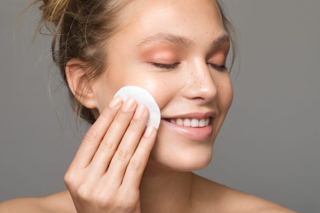Girl toning her face with a cotton pad