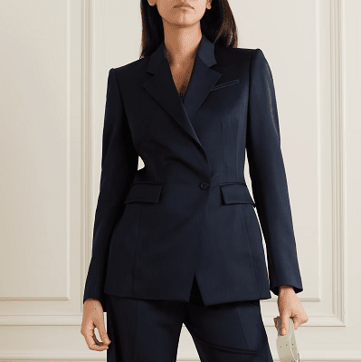 professional woman wears navy pants suit; she wears white pointy-toed flats and a mint green leather shoulder bag