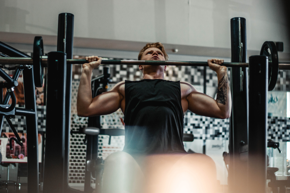 a man utilizing a lat pulldown machine, targeting his latissimus dorsi muscles during a strength training workout