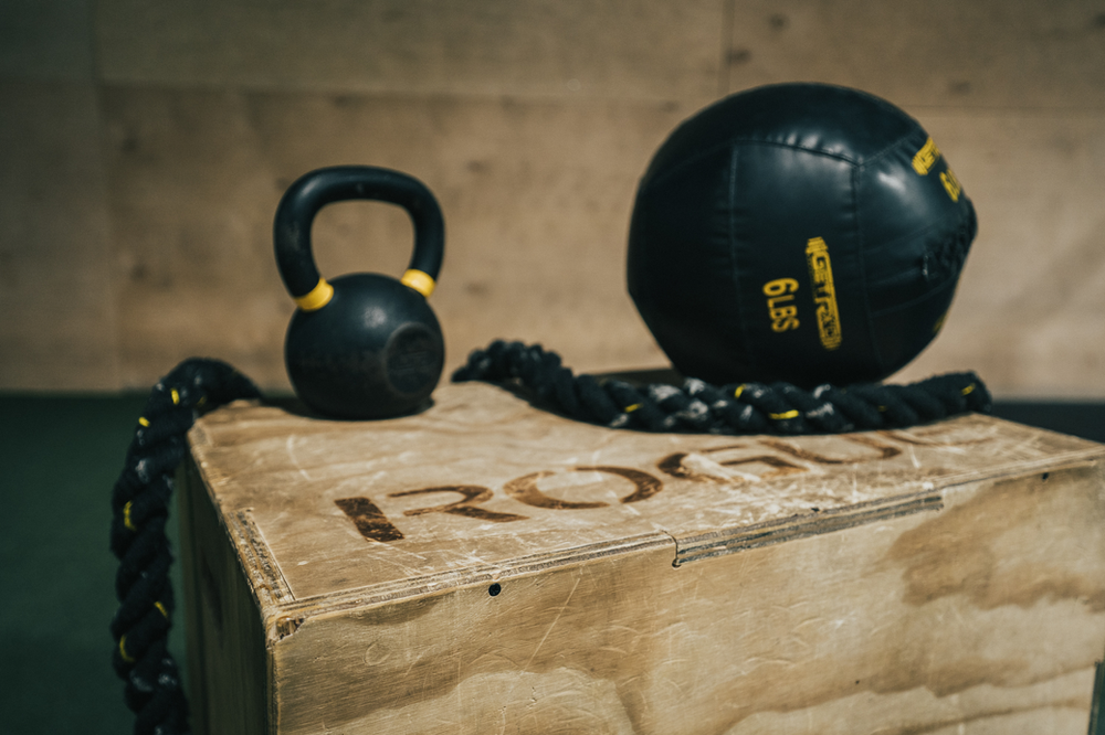 A single kettlebell, resting on the gym floor, ready for use in strength training exercises, showcasing a compact and versatile fitness tool