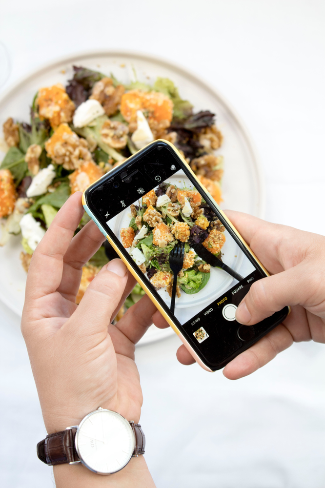 woman taking pictures of her healthy food