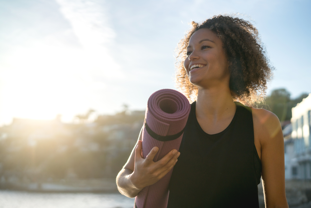 woman with a pilates mat