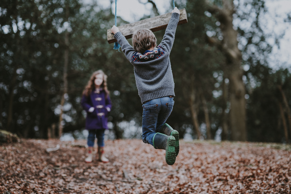 A joyful boy swinging on a swing, highlighting the energy and vitality associated with an active lifestyle. Protein powder can play a role in supporting muscle development and overall well-being, contributing to the strength and vitality evident in the child's play