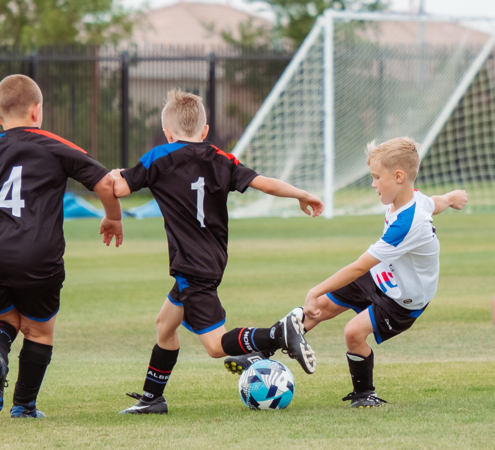 Boys enthusiastically playing soccer, showcasing the physical activity and teamwork associated with sports. Protein powder can be a beneficial supplement to support muscle recovery and growth, enhancing performance for young athletes engaged in dynamic activities like soccer