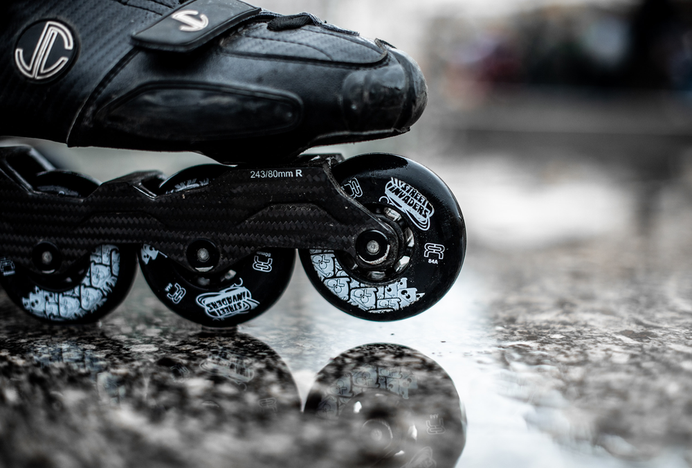 A close-up view of a single rollerblade, highlighting its sleek design, wheels, and fastening mechanisms, providing a detailed look at the equipment for inline skating