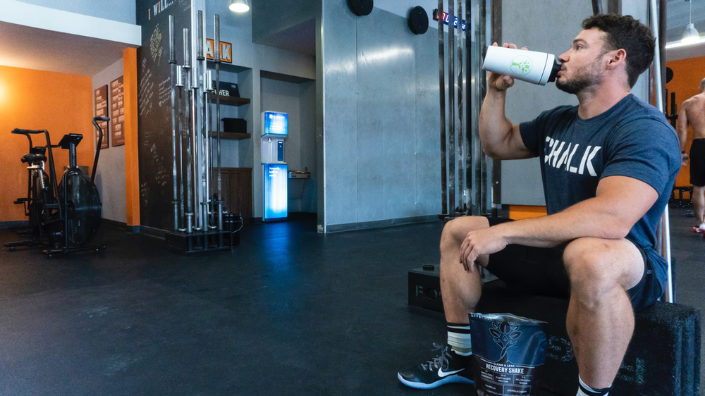 A fitness enthusiast enjoys a post-workout protein shake for muscle recovery. The image depicts a man holding a protein shake bottle, emphasizing the importance of protein consumption after exercise