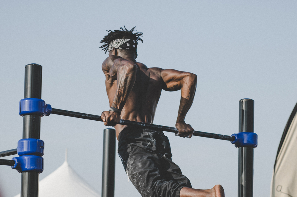 An active man performing dips on a sturdy dip station, showcasing upper body strength and engaged muscles during a home workout session